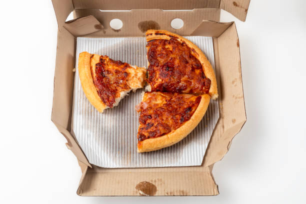 istock Leftover margherita pizza in an open cardboard pizza box isolated on white background. Top view 1570638558