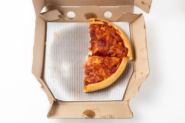 istock Half margherita pizza in cardboard box on white background. Pizza delivery. Top view. 1570639073