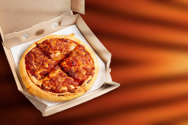 istock Margherita pizza in a box on a brown background with space for text 1570643528