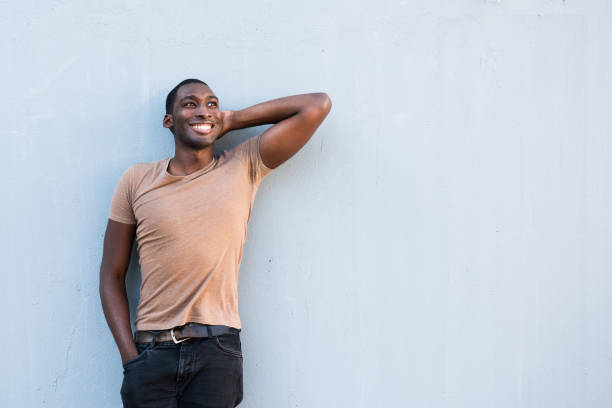 istock cool young African American guy relaxing with hand behind head by gray background 1570687670