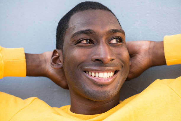 istock Close up smiling young African American man  with hands behind head 1570687697
