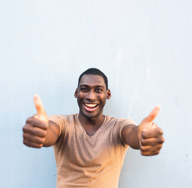 istock Close up laughing young African American man with thumbs up hand sign 1570687708