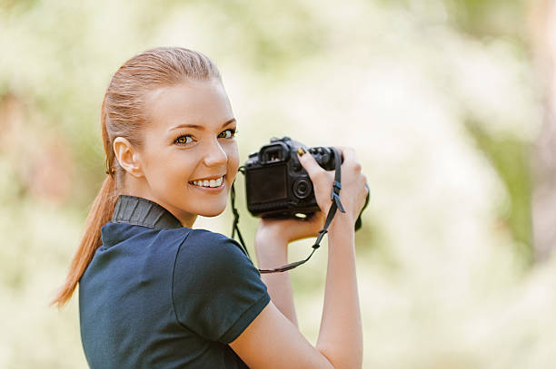 istock smiling young woman with camera 157069599