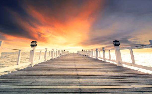 beautiful wood pier against dramatic sunset sky