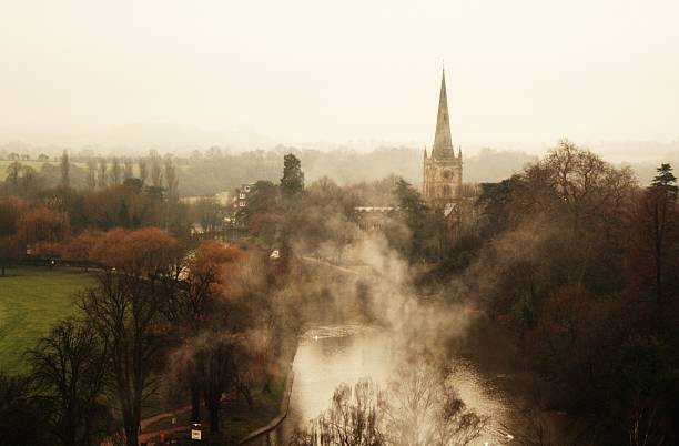 Misty view over Stratford-upon-Avon, featuing the river Avon and Holy Trinity Church.