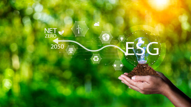 istock Net zero 2050 ESG concept, Hand with green world, wind energy system icon on blurred green leaf background. wind energy for green environment. Businessman background with energy icons around. 1570720957