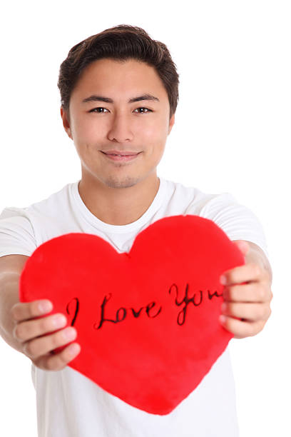 Young man holding a soft heart with the words \