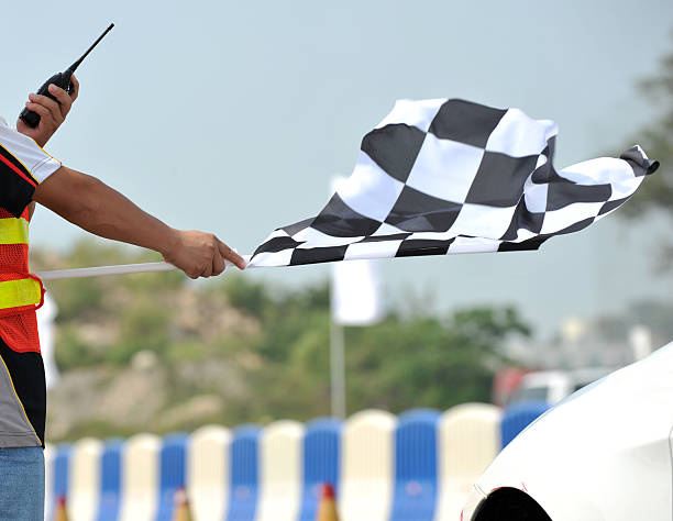 Checkered racing flag being shown to start the race checkered race flag in hand. stock car photos stock pictures, royalty-free photos & images
