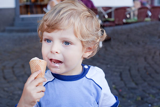 istock Little toddler boy eating ice cream in cone 157077093