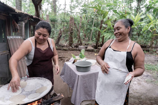 istock Two adult Hispanic women having fun while preparing corn tortillas 1570793495
