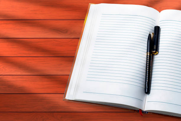 Notebook with pen on wooden table. Top view