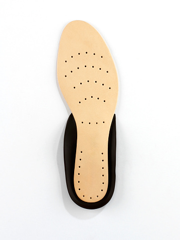 Looking down on a leather inner shoe sole on white background