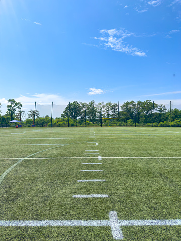 Wide angle view of an empty American football practice field on a summer day