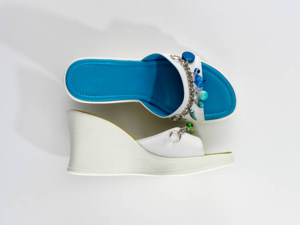 Still life of a pair of slippers in different colors on a white painted textured background
