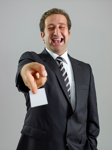 Young businessman giving his business card with a smiley face