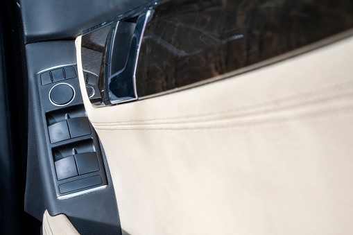 Car door trims with beige leather interior. Modern car door interior