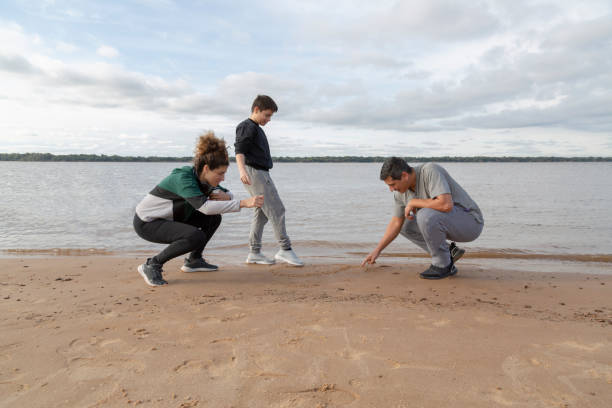 istock family enjoying the river and sand 1570915695