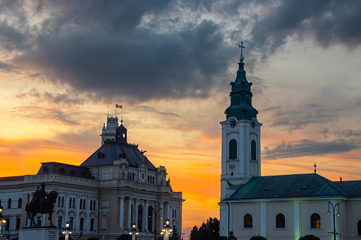 City Hall and Saint Ladislau Church under a dramatic sky at dusk in Oradea, Bihor County, Romania