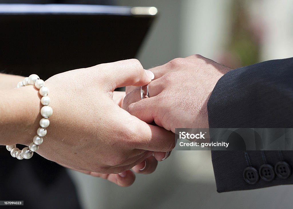 Ring On His Finger A couple exchanging wedding vows and rings on their big day. Authority Stock Photo