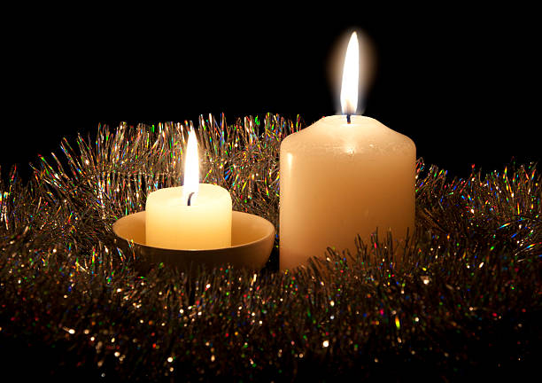 Burning candles with a Christmas-tree decoration stock photo