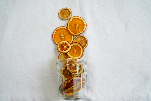 Captivating composition with vibrant hues, presenting a beautiful background that complements the delightful display of dried orange slices in a glass jar.