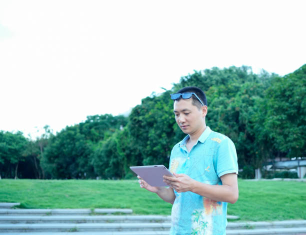 istock Businessmen use tablet computers to work in parks 1570989422