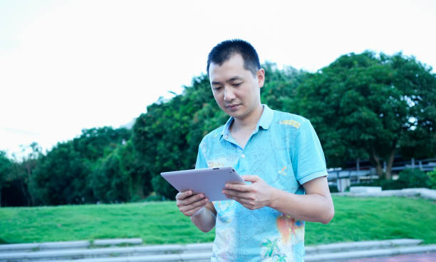 istock Businessmen use tablet computers to work in parks 1570989944