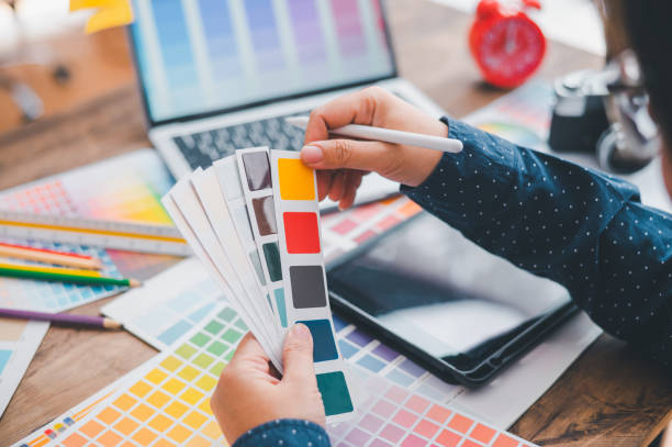 istock Graphic designer architects who work with laptops and color comparison tables for design work. 1571005089