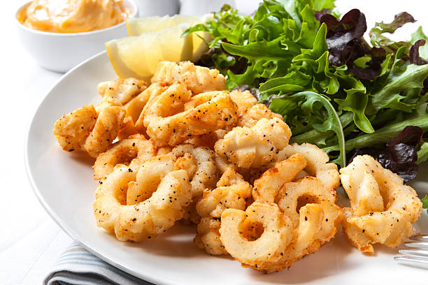 Salt and pepper Squid Salt and pepper squid with a fresh green salad. calamari stock pictures, royalty-free photos & images