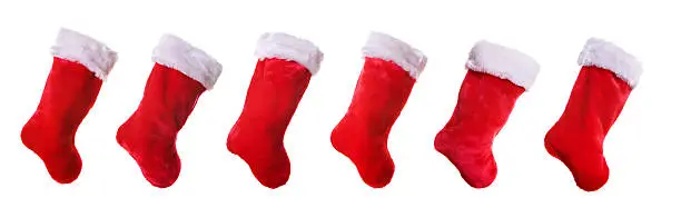 Six traditional red and white Christmas stockings isolated on a solid white background. Happy holidays!
