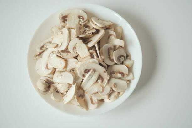 Fresh champignons mushroom in a white bowl on table ,