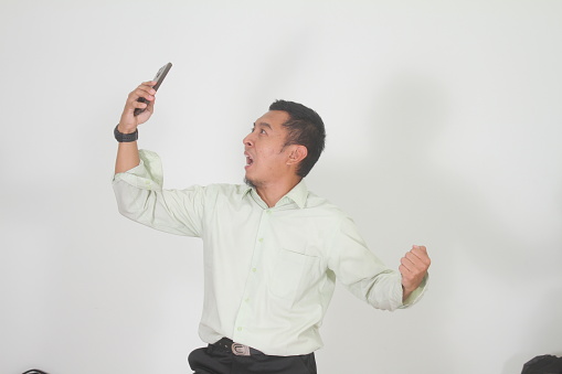 Adult Asian man searching for phone signal with confused expression