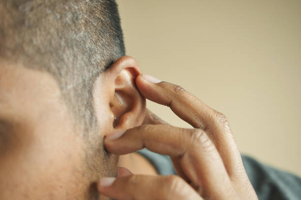 istock young man having ear pain touching his painful ear , 1571060047