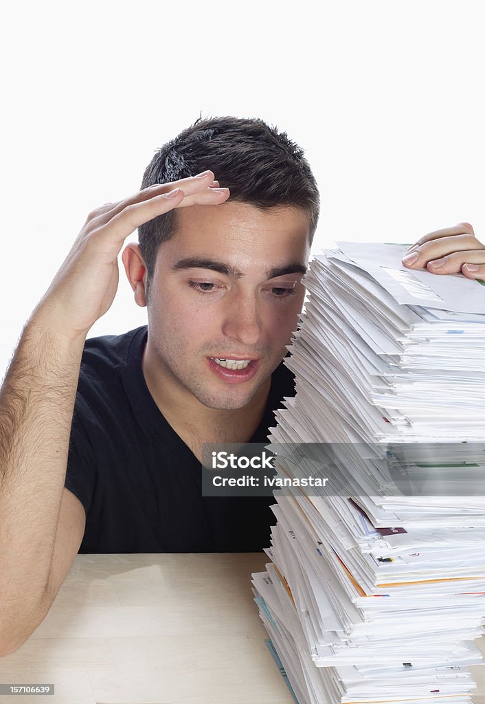 Financial Problems, Young Man with Paperwork Overload and Unpaid Bills Young man working on laptop with a huge pile of unpaid bills 20-24 Years Stock Photo