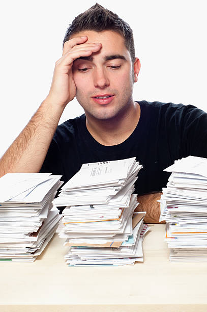 istock Financial Problems, Young Man with Paperwork Overload and Unpaid Bills 157106643