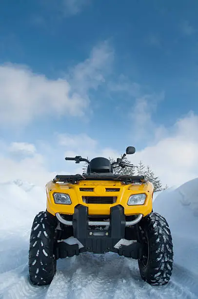 Yellow quadbike on snowy road