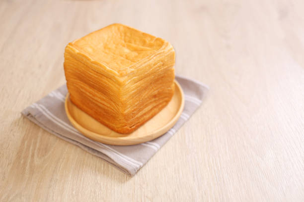 Thousand layer toast on wooden dish with brown napkin
