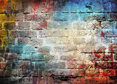 Brick wall with letters and different colors splattered on