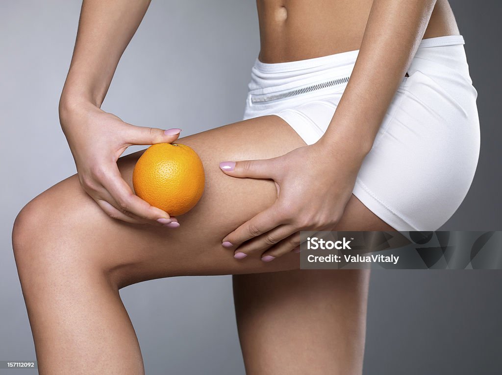 cellulite skin on her legs Female squeezes cellulite skin on her legs - close-up shot on white background Cellulite Stock Photo