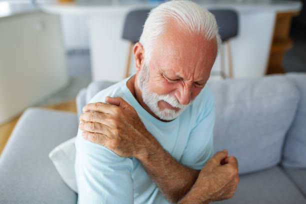 istock Senior elderly man touching his shoulder, suffering from shoulder pain, sciatica, sedentary lifestyle concept. shoulder health problems. Healthcare, insurance 1571125614