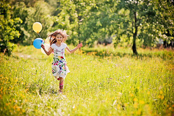 istock Little girl running with balloons 157115328