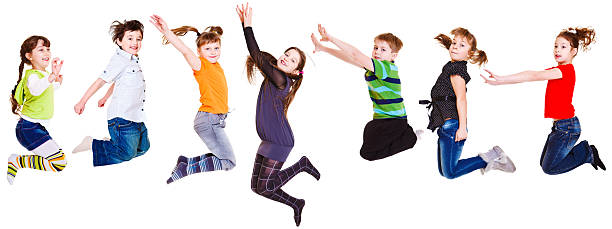 istock Smiling kids jumping in front of a white backdrop 157121621