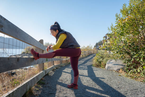 Multiracial Young Woman Using Smart Watch While Stretching on Seawal