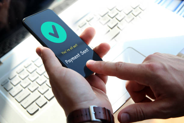 istock Businessman is  using his smartphone and laptop. Payment sent. 1571246923