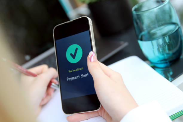 istock Woman using online banking on mobile phone. Payment sent. 1571246931
