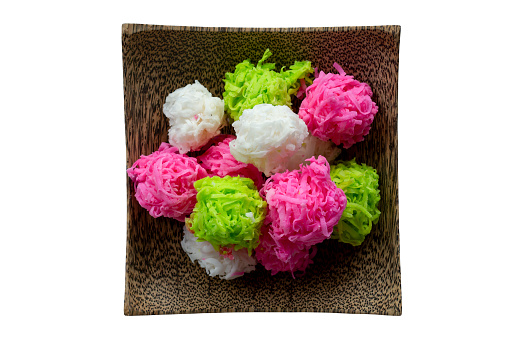 Top view of Coconut candy balls coated sugar or Maprao Keaw in wooden plate is Traditional Thai dessert isolated on white background included clipping path.