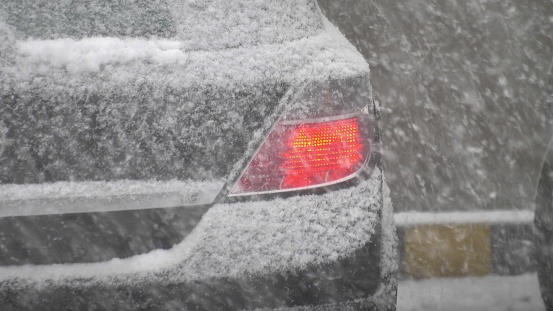 Car Driving on Parking Lot during Heavy Snowstorm Slow Motion