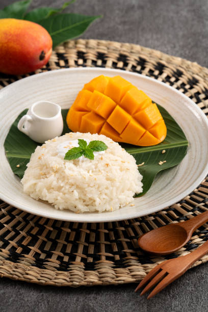 istock Delicious Thai mango sticky rice with cut fresh mango fruit in a plate. 1571278473