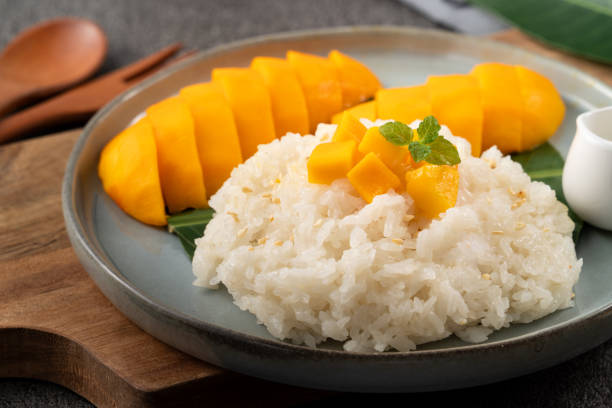 istock Delicious Thai mango sticky rice with cut fresh mango fruit in a plate. 1571278488