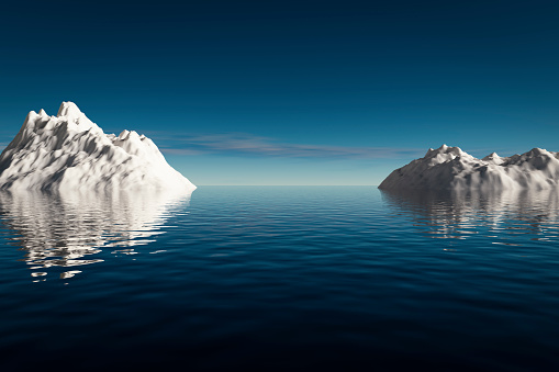 Large white glaciers float in the blue ocean.